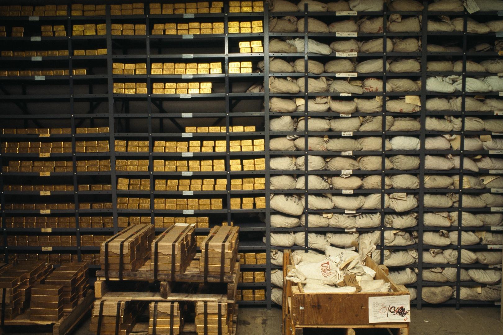 Scale balancing gold bars and a digital token, representing collateral versus yield